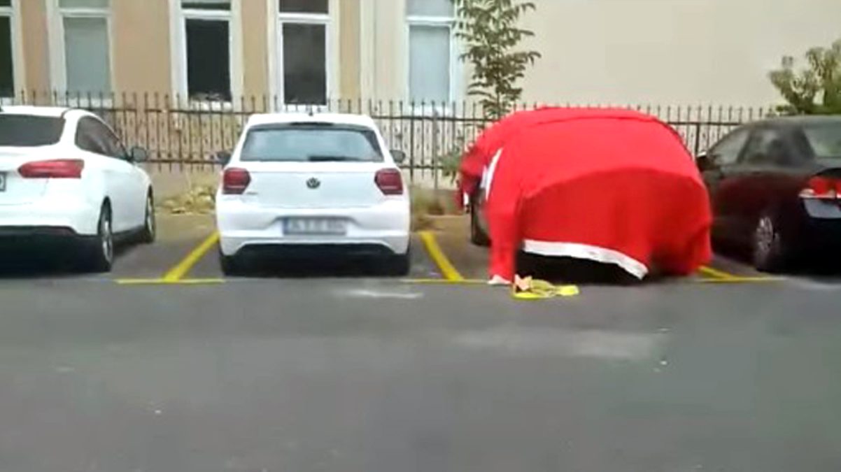 Doludan korumak istediği arabasının üzerine Türk bayrağını örttü
