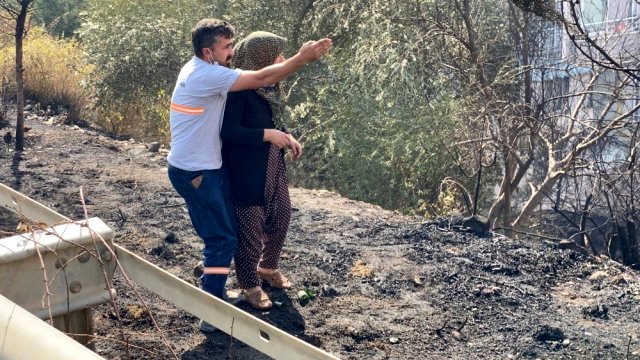Hatay'da yanan evine koşmaya çalışan kadın güçlükle ikna edildi