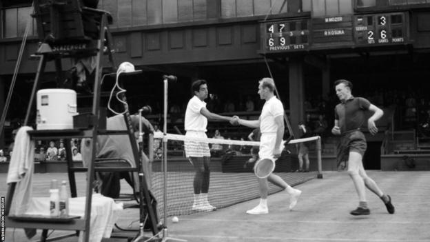 Sam Hill, 1960'ların başında Wimbledon gösteri sahasında oyuncular el sıkışırken filenin etrafında koşuyor.