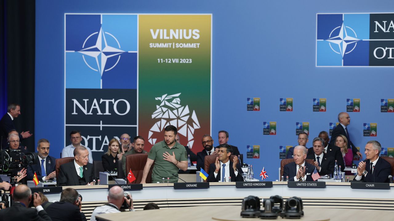 NATO-Ukrayna Konseyi toplantısında tanıtılan Ukrayna Devlet Başkanı Volodymyr Zelenskyy (soldan ikinci), Türkiye Cumhurbaşkanı Recep Tayyip Erdoğan (solda), İngiltere Başbakanı Rishi Sunak (sağdan üçüncü) ve ABD Başkanı Joe Biden (sağdan ikinci) tarafından alkışlandı. 12 Temmuz 2023'te Vilnius'taki NATO Zirvesi sırasında. 